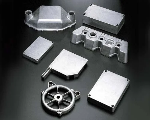 The image shows a group of aluminum parts on a black surface, which appear to be die-cast aluminum parts. The parts are arranged in a neat and orderly fashion, with some of them overlapping each other