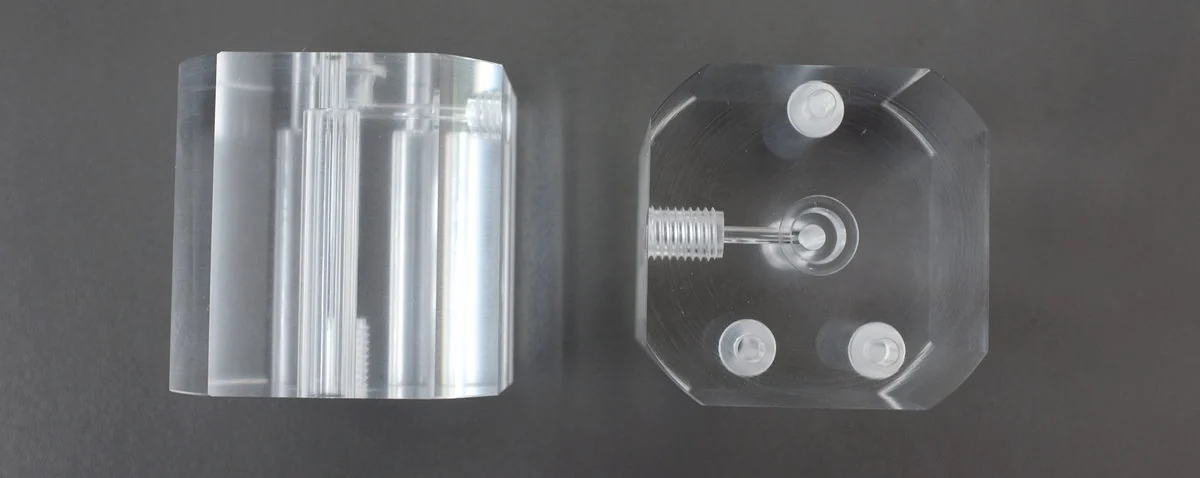 Clear acrylic machined parts before and after polishing on a dark inspection surface