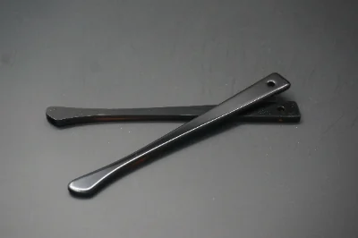 Polished black acetate eyeglass temples showing edge and hinge details