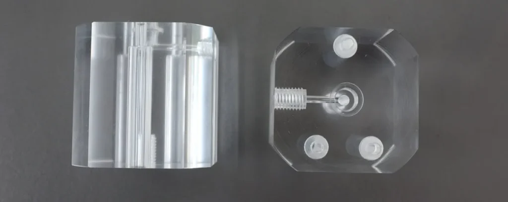 Clear acrylic machined parts before and after polishing on a dark inspection surface