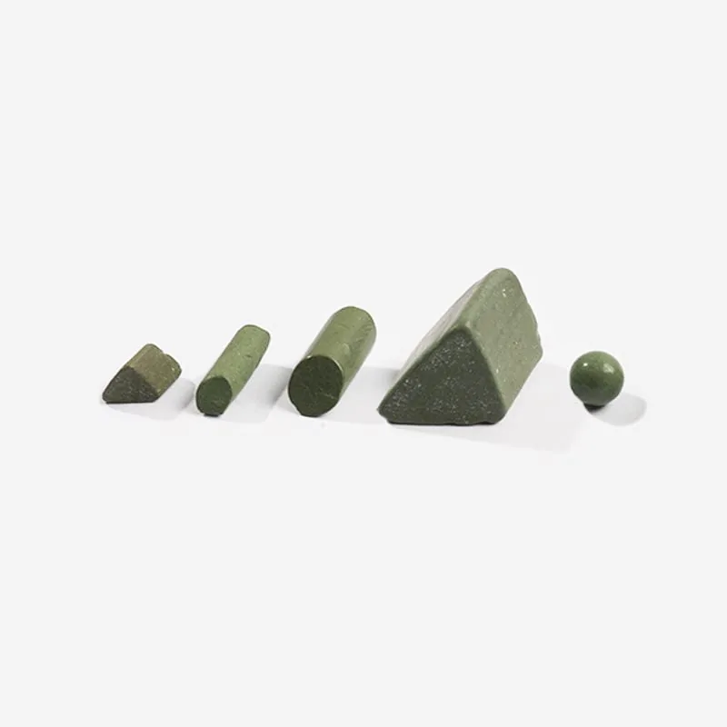 The image shows a set of four green stones on a white surface, which appear to be a stone block and a stone ball. The stones are arranged in a triangular formation, with the stone block in the center