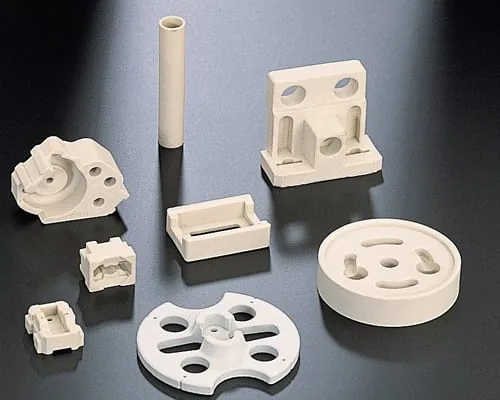 The image shows a group of white plastic parts sitting on top of a table. The parts appear to be part of a 3D printing process, as they are arranged in a neat and orderly fashion. The white color of t