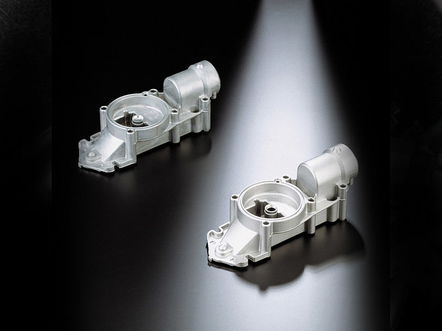 Two aluminium die-cast components finished to an even surface, showing consistent results across a batch