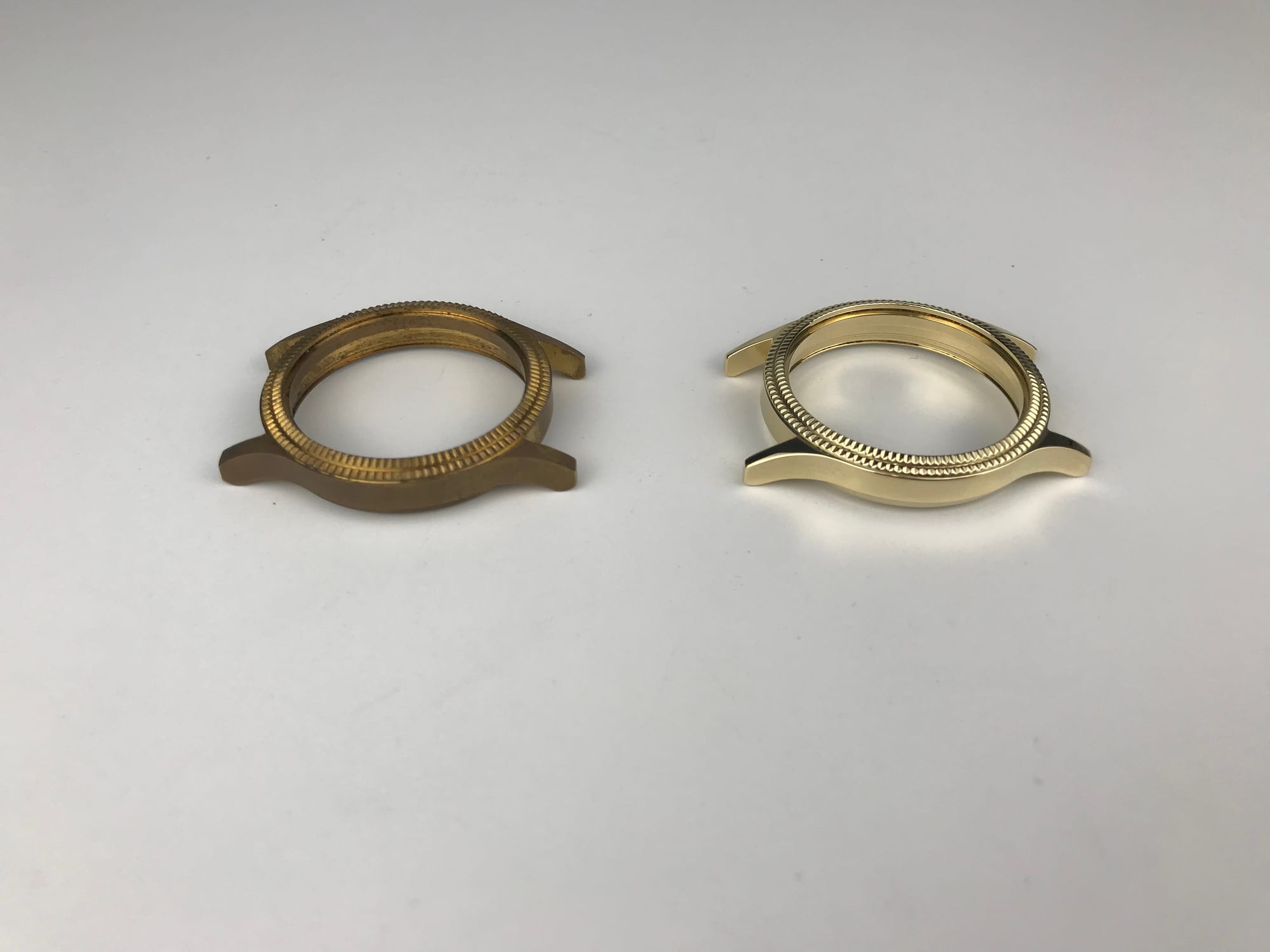 Two brass watch bezels side by side: the left one still dull yellow-brown, the right one bright gold after finishing