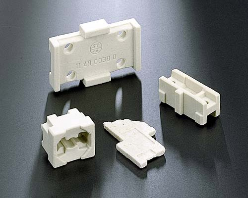Plastic electronic connector housings and contact carriers