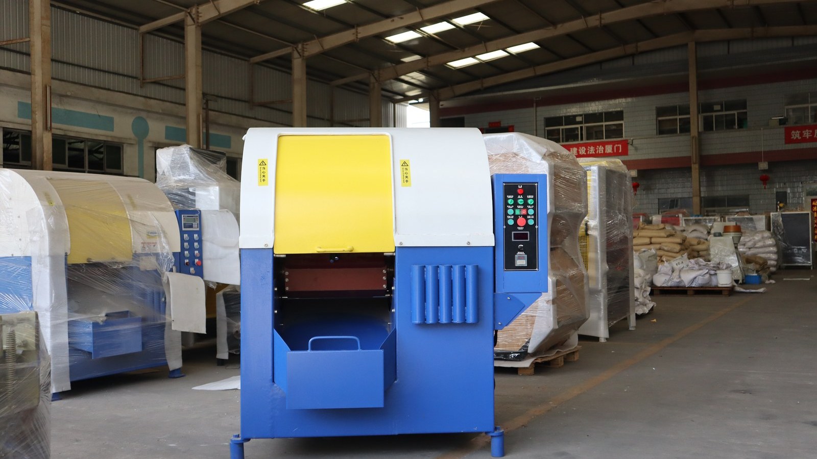A finishing machine on the workshop floor, with the rest of the order wrapped behind it